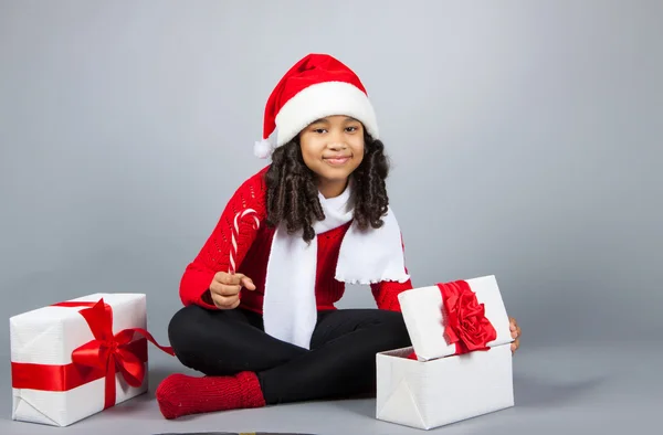 Fille avec un cadeau de Nouvel An. Joyeuse fille dans une casquette du Père Noël — Photo