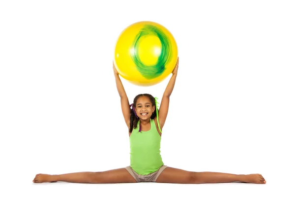 Chica se dedica a la gimnasia. niño sentado en las divisiones . — Foto de Stock