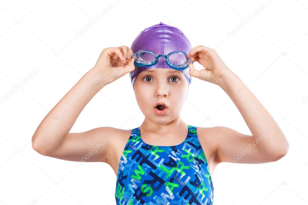 Portrait of a young girl in goggles and swimming cap.