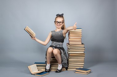 Gözlüklü kız kitap okuyor.