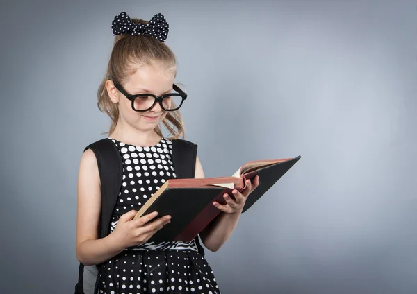 Маленькая умная девочка читает книгу — стоковое фото