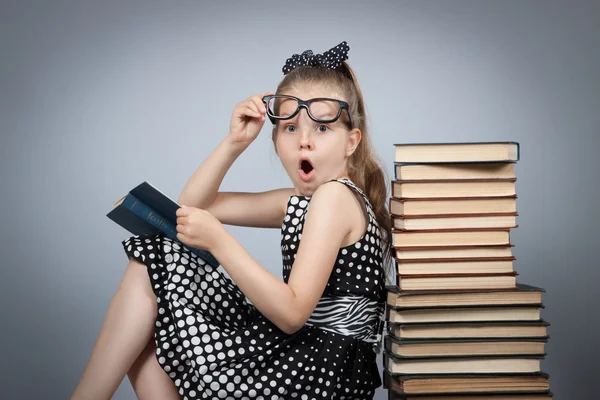 Girl  reading a book and is very surprised — Stock Photo, Image