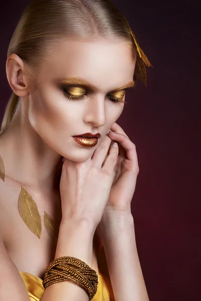 Belle femme en accessoires avec des feuilles d'or — Photo