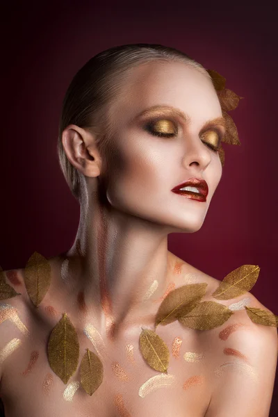 Красива жінка в аксесуарах з золотим листям — стокове фото