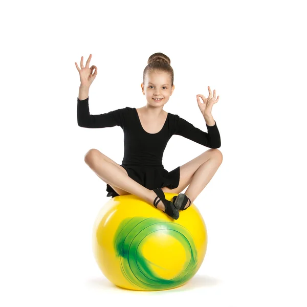 Girl in the lotus position on a big yellow balloon — Stock Photo, Image