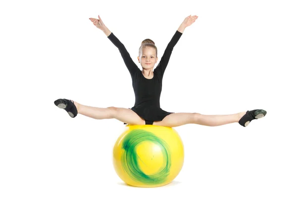 Girl does exercises on a big yellow balloon — Stock Photo, Image