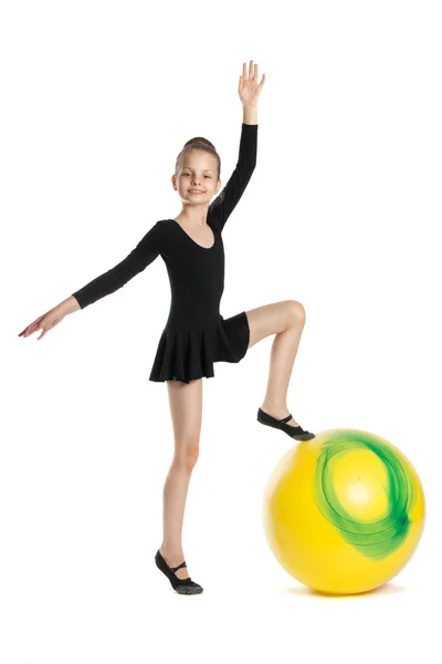 Girl does exercises on a big yellow balloon — Stock Photo, Image