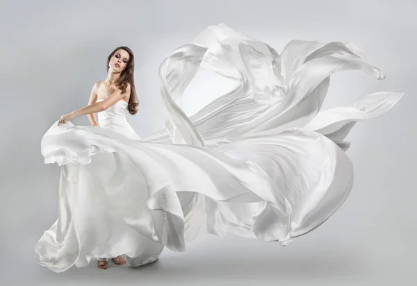 Beautiful young girl in flying white dress. Flowing fabric — Stock Photo, Image