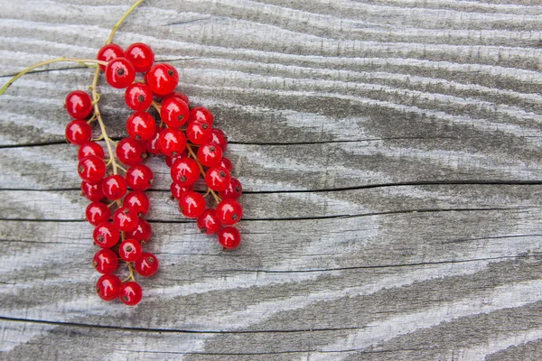 Grosellas rojas sobre una textura de madera — Foto de Stock