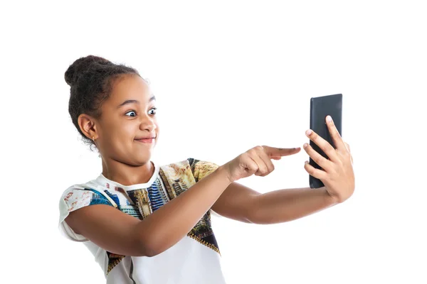 Chica adolescente feliz mirando la pantalla de la tableta. Chica de piel oscura se divierte señalando — Foto de Stock