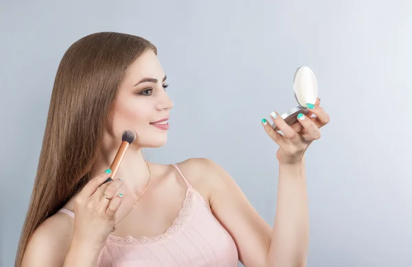 Make-up. Kosmetik. das Mädchen schminkt sich im Spiegel — Stockfoto