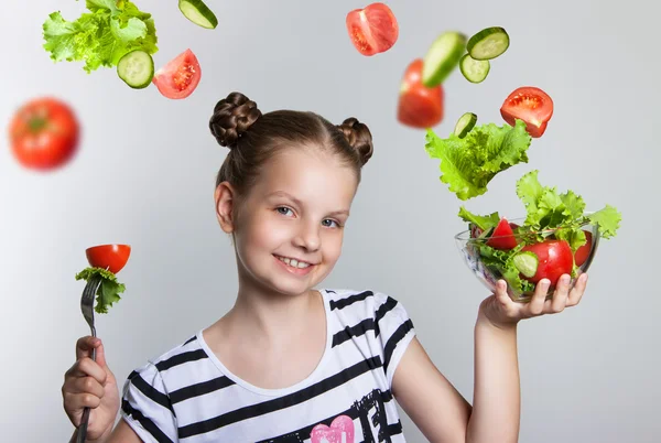 Красивая улыбающаяся девушка держит тарелку с овощами — стоковое фото