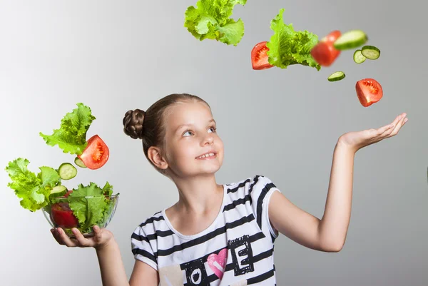 Bella ragazza sorridente che tiene un piatto con verdure — Foto Stock