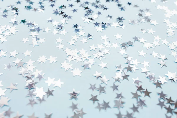 Estrelas de confete de folha de prata no fundo azul — Fotografia de Stock