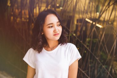 Beyaz gömlekli genç Asyalı kadın, sokak portresi.