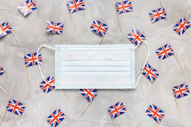 Beyaz sağlık maskeleri ve İngiliz bayrakları