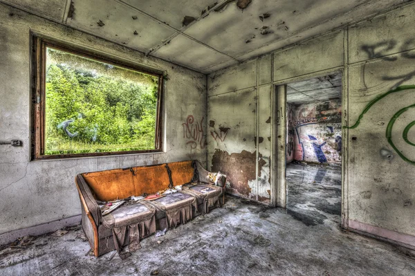 Sofá podrido en una habitación abandonada — Foto de Stock