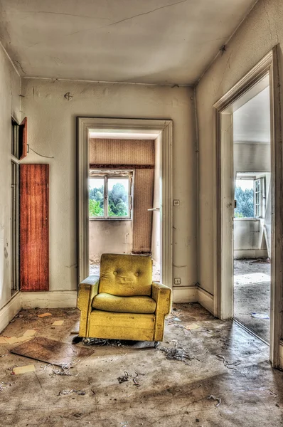 Желтое кресло в заброшенном доме — стоковое фото