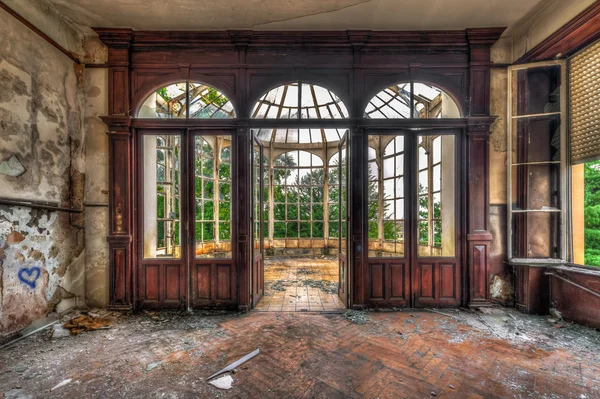Verlassenes Zimmer mit Blick durch schönen zerbrochenen Wintergarten — Stockfoto