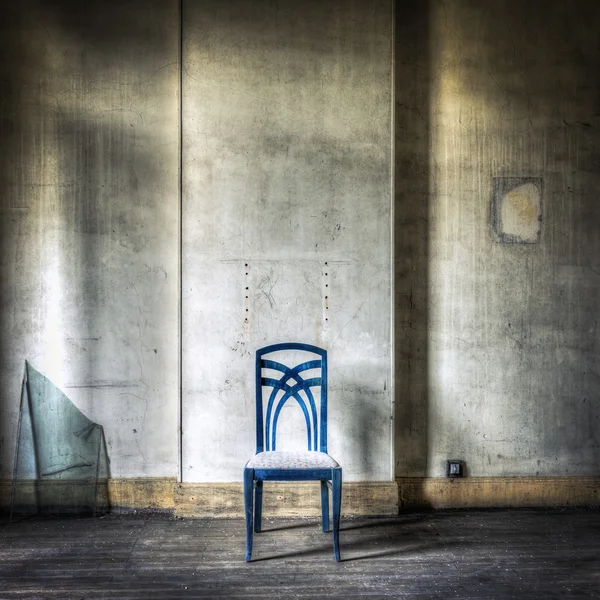 Silla azul solitaria en un interior gruñón — Foto de Stock