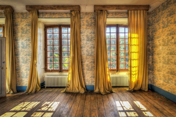 Fenster mit gelben Vorhängen in einem verlassenen Schloss lizenzfreie Stockfotos