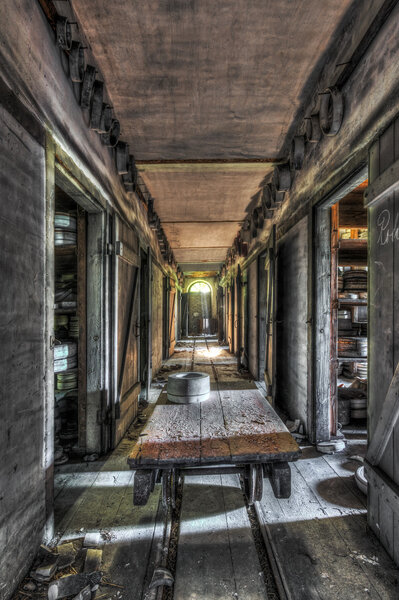 Carriage on rails crossing the hallway of an abandoned pottery