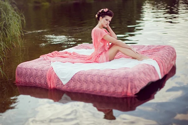 Femme assise sur le lit dans une rivière — Photo