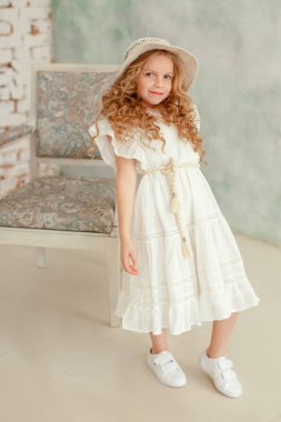 Stüdyoda poz veren küçük sarışın kız. Moda ve zamansız fotoğrafçılık. 