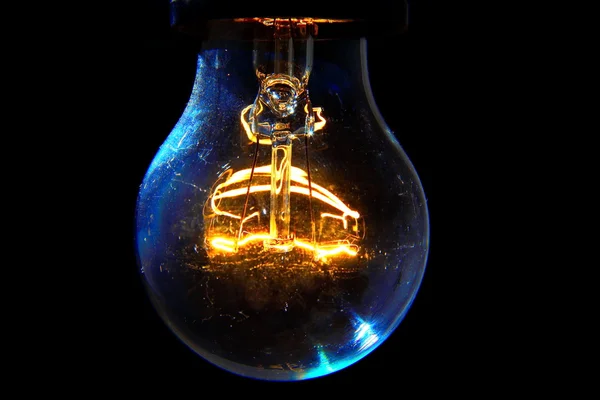 Old light bulb glowing in dark — Stock Photo, Image
