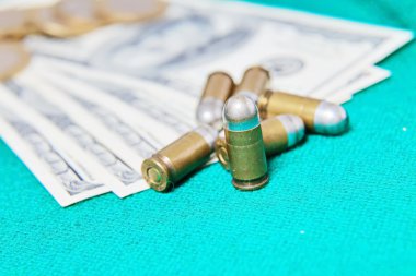 Dolar ve casino fişi ve tabanca mermi yeşil kumaş üzerine