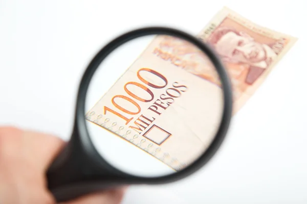 Büyüteç Kolombiyalı peso üzerinde.
