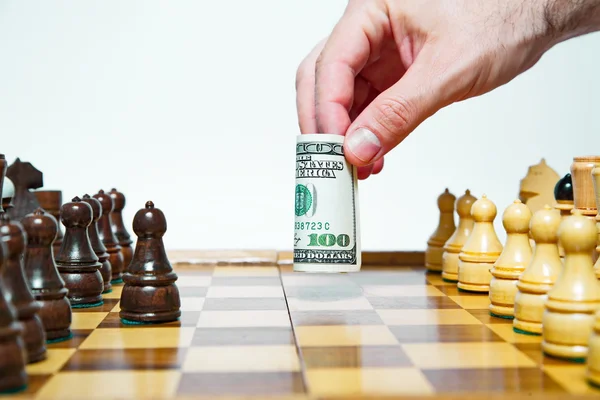 L'homme joue aux échecs avec une facture de cent dollars et fait bouger — Photo