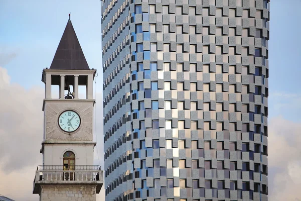 TIRANA, ALBANIA - 22 OTTOBRE: Vecchia Torre dell'Orologio contro il nuovo edificio, torre costruita nel 1822 il 22 ottobre 2014 a Tirana, Albania — Foto Stock