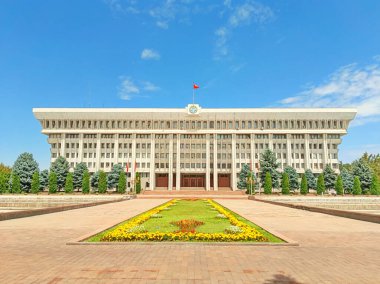 Bişkek, Kırgızistan - 12 Haziran 2024: Klasik bir cephe ve bayrakla çevrili büyük idari bina,