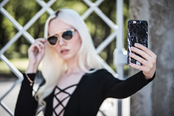 Mooie jonge blonde vrouw selfie in het park — Stockfoto