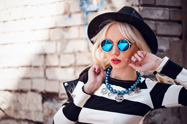 Stijlvolle blonde model in zonnebril buitenshuis — Stockfoto