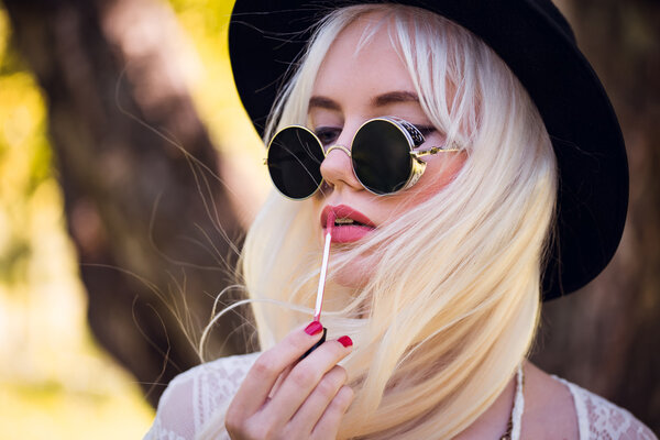 Stylish blonde model in sunglasses with lipstick