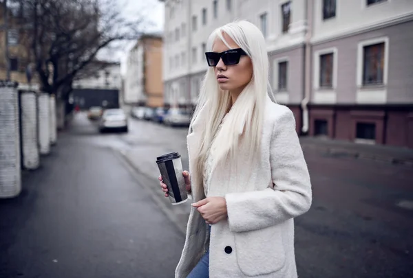 Hermosa modelo rubia en gafas de sol con café al aire libre — Foto de Stock