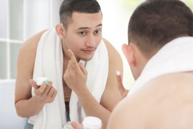 man applying moisturizer cream clipart