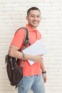 bazı kitaplar taşıyan üniversite öğrencisi