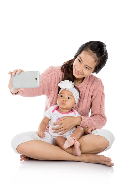 Mulher com bebê tomando selfie — Fotografia de Stock