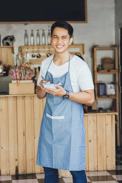 Männlicher Kellner in Schürze Schreibauftrag — Stockfoto