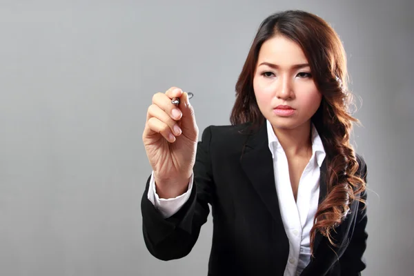 Businesswoman writing on grey — Stock Photo, Image