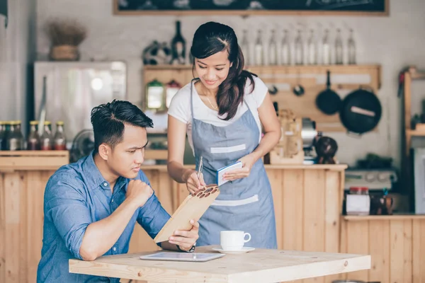 Garçonete feminina explicar sobre menu — Fotografia de Stock