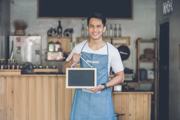 Männlicher Café-Besitzer mit leerem Brett — Stockfoto