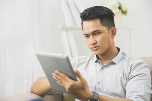 Homem usando tablet pc em casa — Fotografia de Stock