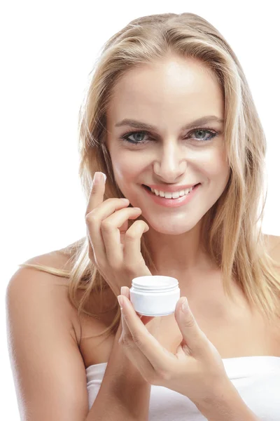 Mujer aplicando crema facial en la mejilla — Foto de Stock
