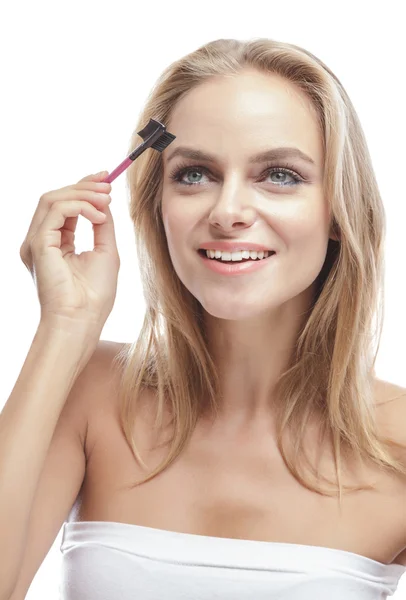 Blonde woman using eyebrows comb — Stock Photo, Image