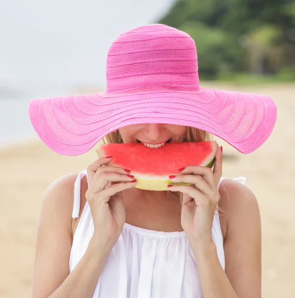 Femme en chapeau rose mangeant pastèque — Photo