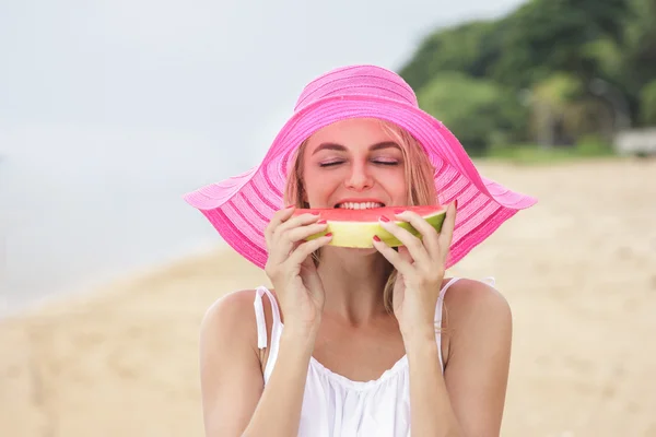 Frau mit rosa Sonnenhut isst Wassermelone — Stockfoto